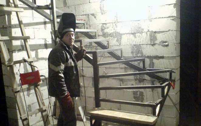 un métallier serrurier travaillant sur un escalier en métal