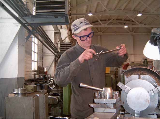 un serrurier métallier dans son atelier en train de fabriquer une pièce en métal